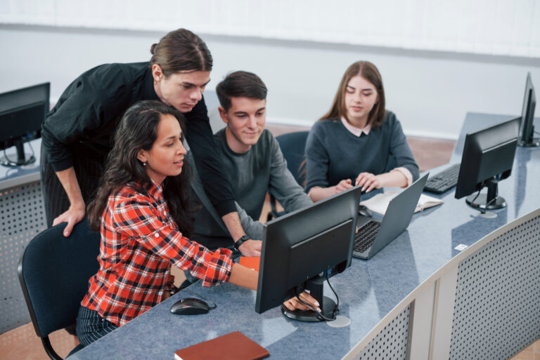 Group of young people in casual clothes working in a modern office